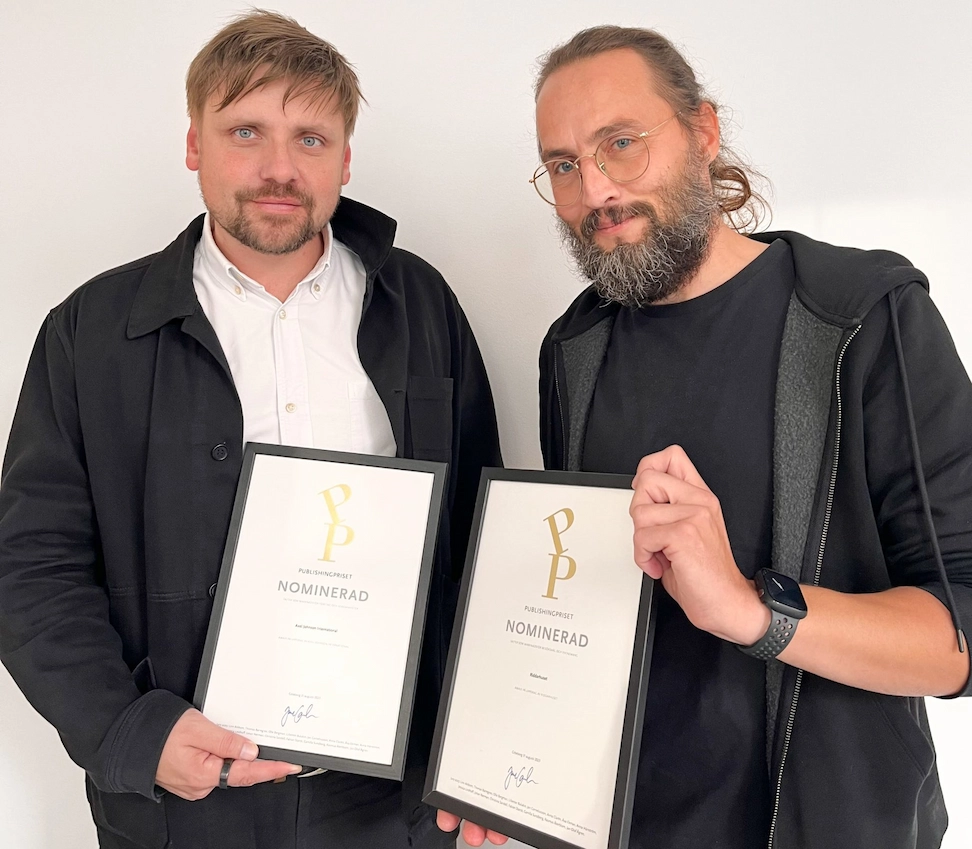 2 män håller upp 2 diplom om att vara nominerade till publishingpriset 2023!
