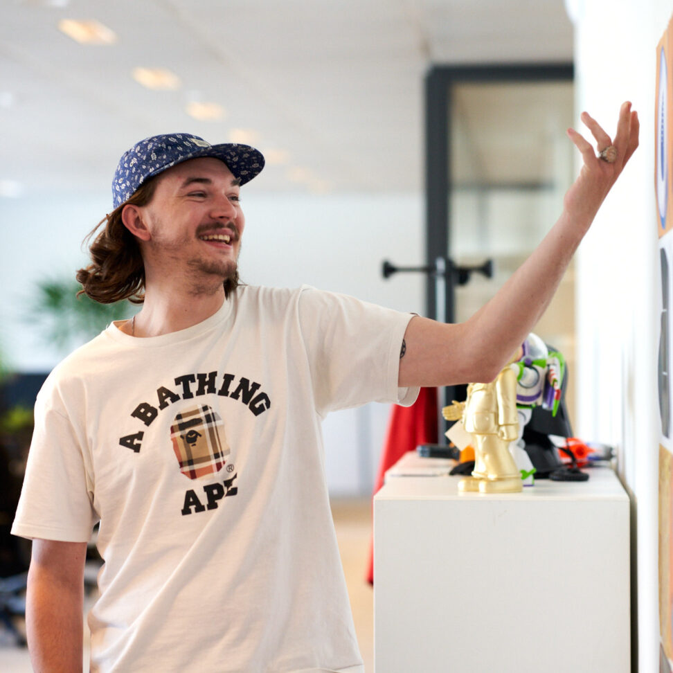 En medarbetare iklädd vit t-shirt som betraktar en färgglad väggmålning eller konstverk under en inspirationsdag