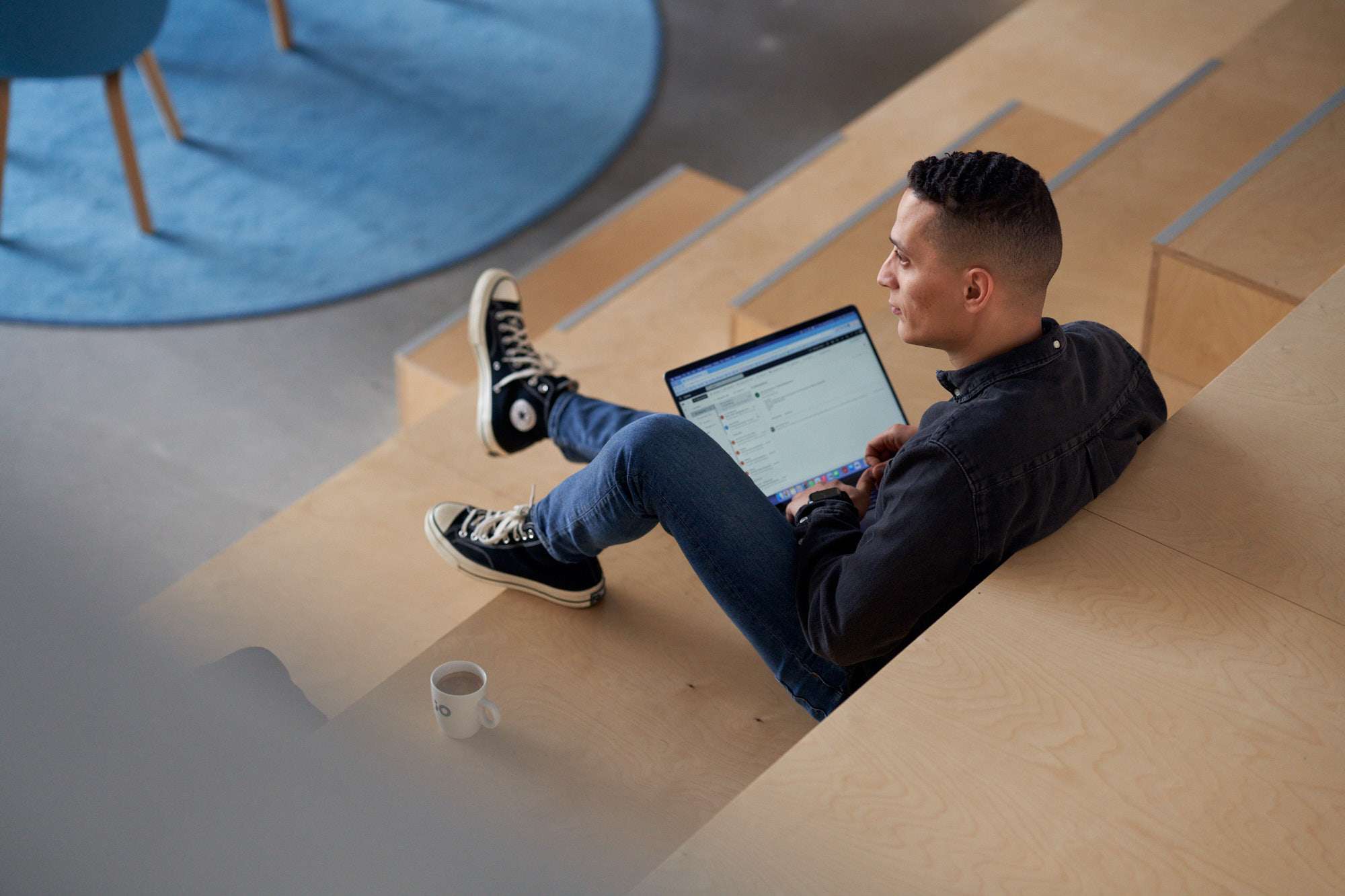 En man sitter i en trappa med en dator i knät