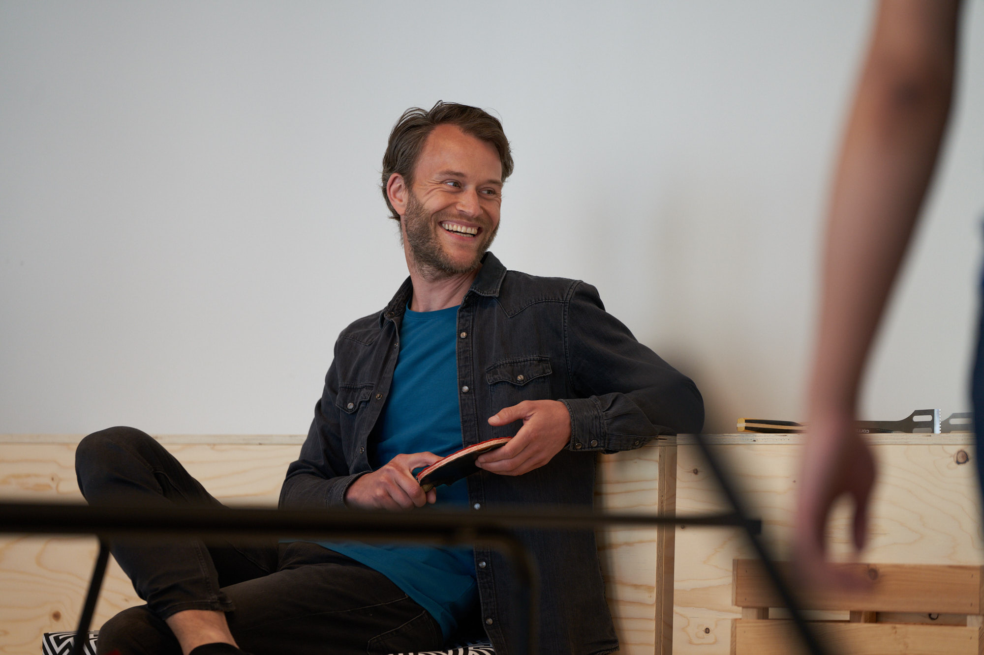 En man håller ett pingisracket och skrattar